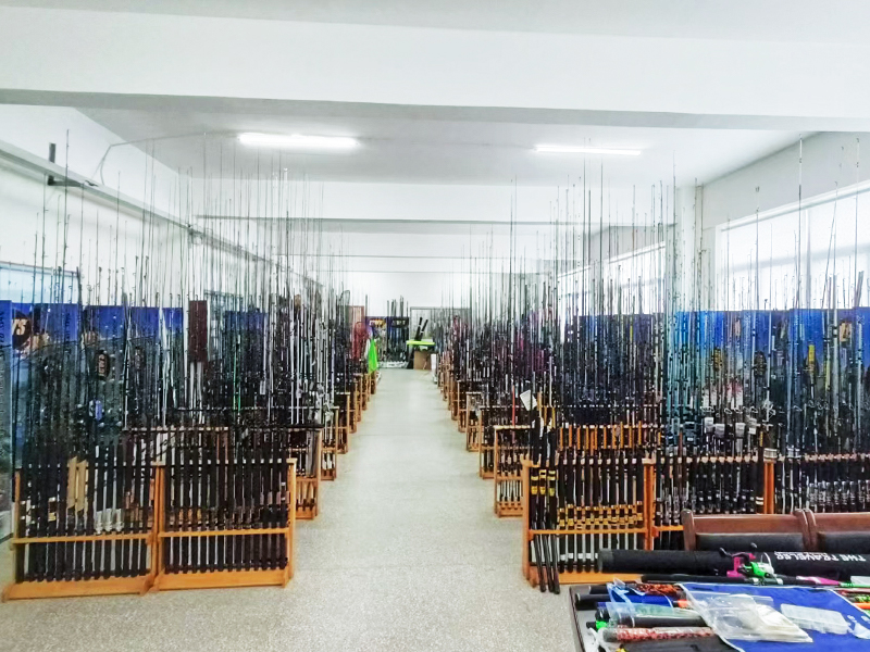 Display of various fishing rods including carbon fiber options, alongside fishing reels and lures, offering comprehensive fishing accessories for enthusiasts.