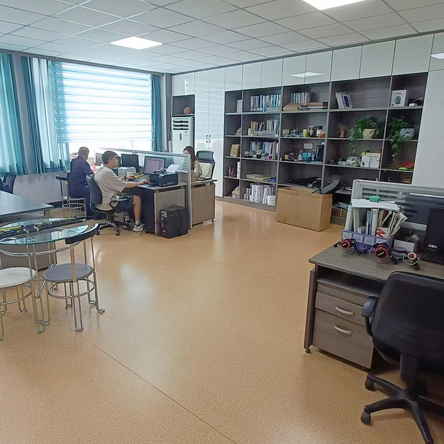 Office space with a large window overlooking mountains, featuring a wall display of various fishing rods, reels, and lures, emphasizing quality and selection.